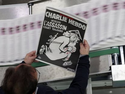 Un empleado de una imprenta sostiene una copia de la última edición del semanario francés 'Charlie Hebdo'.