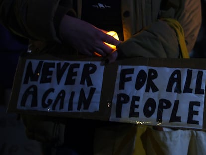 A woman carrying a sign attends a candlelight vigil for the college students who were shot in Burlington near the University of Vermont, November 27, 2023.