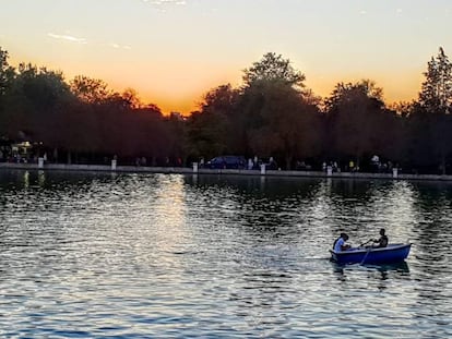 Varias personas pasean en una barca por El Retiro.