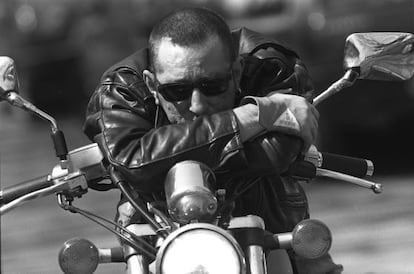 Enrique Sierra cantante de Radio Futura sentado en una moto