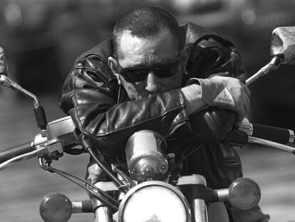 Enrique Sierra cantante de Radio Futura sentado en una moto 