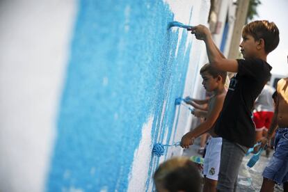 Niños pintando en las paredes de La Cañada, de la mano del colectivo Boa Mistura