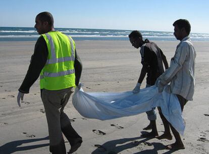 Miembros de las ONG locales recogen el cadáver de uno de los inmigrantes muertos cerca de las costas de Yemen