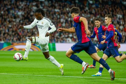 El centrocampista francés del Real Madrid Eduardo Camavinga dirige el balón ante la presión del FC Barcelona, durante el partido entre el Real Madrid y el FC Barcelona.