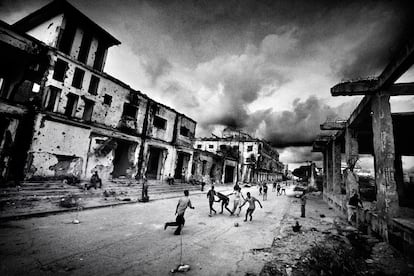 Un grupo de ni?os juega al ftbol en una calle de Mogadiscio entre edificios en ruinas por los enfrentamientos armados.  Esta fotografa forma parte de <i>Somalia en el fin del mundo</i>, reportaje fotogrfico galardonado con el Premio Ortega y Gasset de Fotografa 2009, publicado en el <i>Magazine</i> de <i>La Vanguardia</i> del 1 de febrero de 2009.