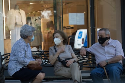 Unos jubilados conversan en un banco, en Madrid
