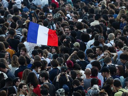 Un manifestante porta una bandera francesa en la Plaza de la República, este domingo en París.