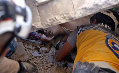 Miembros de la defensa civil siria (Cascos Blancos) sacan a un hombre herido entre los escombros de un edificio derrumbado, depués de los ataques aéreos perpetrados por las fuerzas del régimen sirio en la ciudad de Maaret al-Numan (Siria).