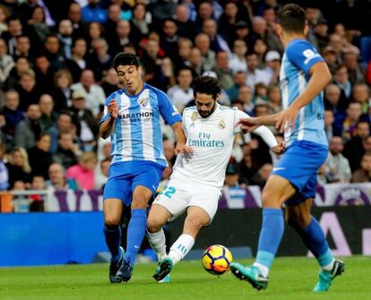 El centrocampista del Real Madrid Francisco Alarcón 'Isco' disputa un balón con el defensa del Málaga Luis Hernández durante el partido correspondiente a la decimotercera jornada de LaLiga Santander disputado hoy en el estadio Santiago Bernabéu.