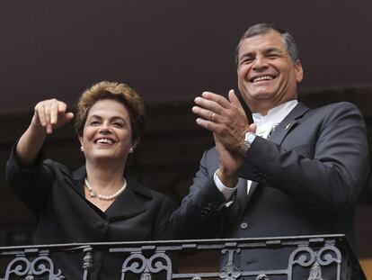 Os presidentes do Brasil, Dilma Rousseff (à esq.), e do Equador, Rafael Correa, acenam de uma sacada em Quito.