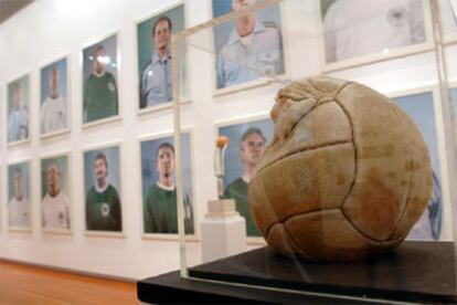 <i>Fortuna</i>, una obra del artista rumano Daniel Spoerri, expuesta frente a las fotografías de los integrantes del equipo alemán que participó en el Mundial de 1974, del artista Volker Schrank.