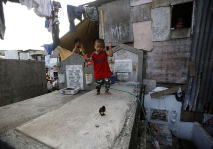 Muchos cementerios públicos en Metro Manila son el hogar de miles de filipinos que comparten espacio con los muertos. En la foto, un niño camina sobre una tumba del cementerio público de Pasay City, al sur de Manila.