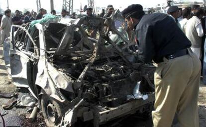 Un policía observa el coche bomba tras la explosión en Lahore.