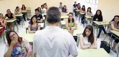 Varios aspirantes a unas oposiciones, en una clase.