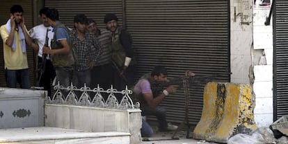 Un grupo de rebeldes vigilan la zona de una base militar cercana a Alepo.