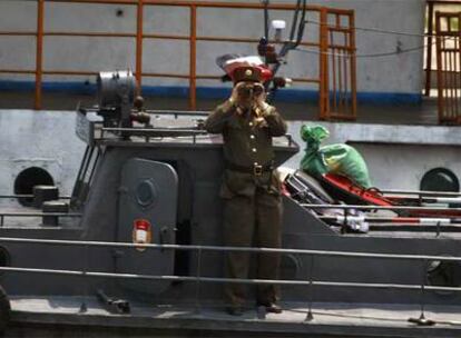 Un soldado norcoreano vigila el paso de los barcos chinos por el río Yalu cerca de Dandong.