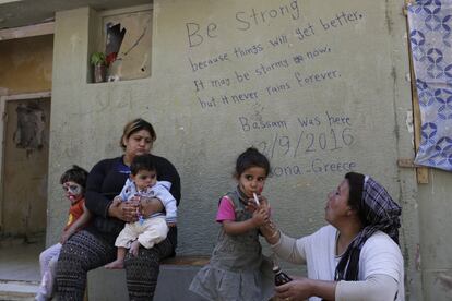 In this photo taken on Tuesday, Sept. 13, 2016, a Kurd Syrian mother gives cough syrup to her child at Ritsona refugee camp north of Athens. Most of the people at the camp arrived in Greece in March, crossing to Lesbos and Chios just ahead of an agreement between the EU and Turkey that took effect. Under the deal, anyone arriving on Greek islands from Turkey on or after March 20 would be held on the island and face being returned to Turkey. Balkan countries began restricting crossings of their borders in early 2016, and shut them completely in early March, stranding tens of thousands of people in Greece (AP Photo/Petros Giannakouris)