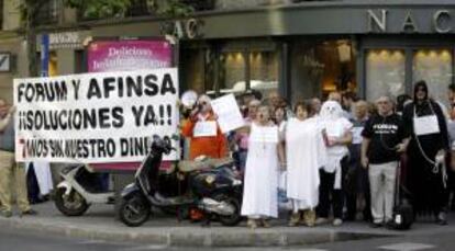 Miembros del Colectivo de Perjudicados CALLE GÉNOVA de Fórum y Afinsa, durante la concentración que han protagonizado hoy ante la sede del PP para reclamar al Gobierno soluciones a su situación. EFE/Archivo