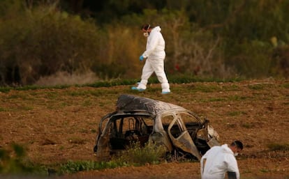 Peritos legais junto ao veículo queimado de Caruana Galizia em 16 de outubro em Bidnija, Malta.