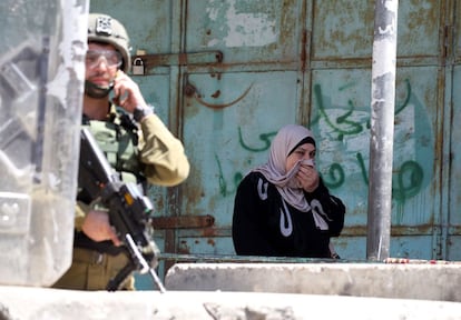 Una mujer se protege de los gases lacrimógenos lanzados durante los enfrentamientos entre el ejército israelí y los palestinos, en la ciudad de Hebrón, Palestina.
