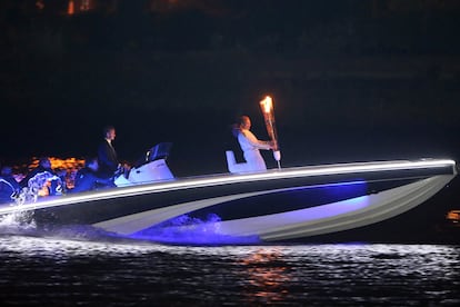 David Beckham junto a la antorcha olímpica se acerca al estadio por el Támesis en una lancha. 