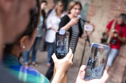 Decenas de vecinos se han acercado a la rueda de prensa de Ada Colau en la sede del distrito de Nou Barris y la han grabado con sus moviles.