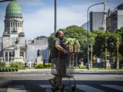 Un hombre con un carrito de supermercado cruza la Avenida de Mayo el 27 de marzo de 2020 en Buenos Aires, Argentina.