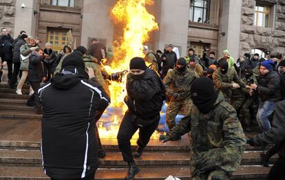 Un hombre sale ardiendo mientras se queman unos neumáticos en los alrededores del Ayuntamiento de Kiev (Ucrania).