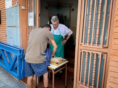 Un voluntario de un comedor comunitario de Cáritas le entrega a Pablo Ruiz algunos alimentos en julio.