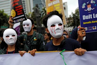 Jornalistas indonésios usam máscaras durante a marcha do Dia Internacional do Trabalho, em Jacarta (Indonésia).