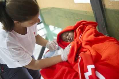 Un voluntario de la Cruz Roja atiende a un niño en el pabellón de Tarifa.