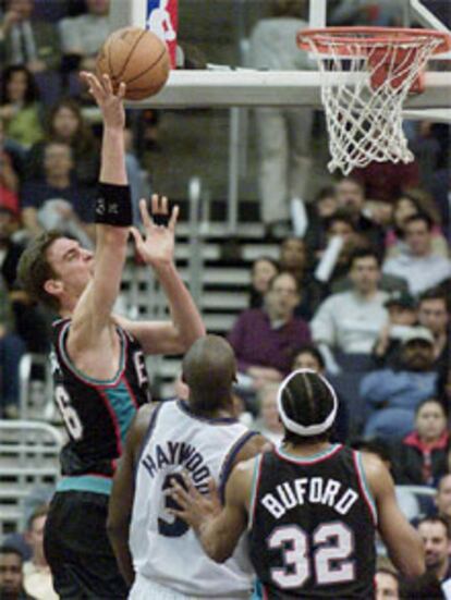 Gasol se eleva sobre Haywodd y su compañero Budford para lanzar a canasta.