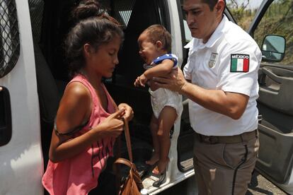 Um policial mexicano segura um bebê enquanto a mãe dele arruma a bolsa para entrar no carro policial com destino a um centro de custódia de migrantes, nesta segunda, 22 de abril. Centenas de migrantes da América Central foram detidos quando caminhavam com destino aos EUA.