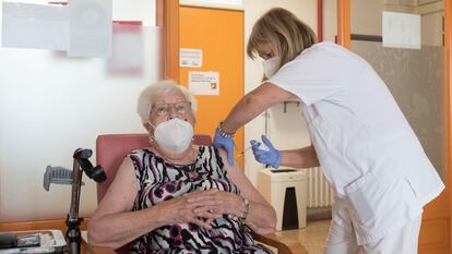A resident of a senior home is given a third shot of a Covid-19 vaccine.