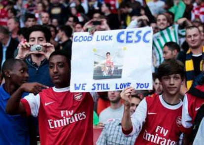 Dos seguidores del Arsenal sostienen una pancarta en la que desean buena suerte al excapitán del Arsenal.