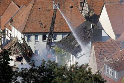 Los bomberos trabajan en los trabajos de limpieza en dos edificios destruidos por una explosión de gas en Lehrberg, Alemania.