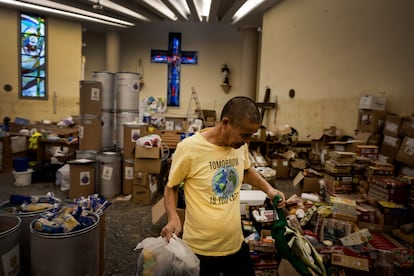 Un hombre recoge productos de una parroquia en Paiporta, este lunes. 