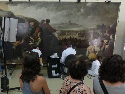 Visitantes observan la restauración del cuadro 'La multiplicación de los panes y los peces', de Murillo.