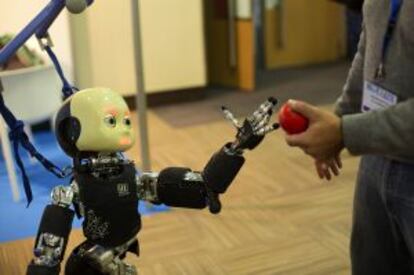 El robot Icub tomando un objeto de un asistente al Humanoids 2014.