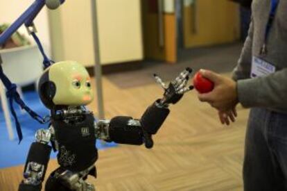 El robot Icub tomando un objeto de un asistente al Humanoids 2014.