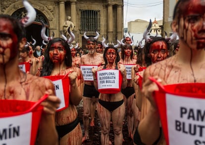 Cerca de 100 activistas han protestado este martes en la plaza Consistorial de Pamplona contra las corridas de toros y los encierros que se celebrarán durante los Sanfermines. En la imagen, varias mujeres sostienen un cartel con el lema 'Pamplona: bloodbath for bulls' ('Pamplona: baño de sangre por los toros').