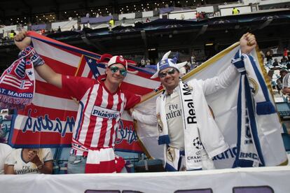 Un aficionado del Atlético de Madrid (i) junto a otro del Real Madrid (d) en el estadio Santiago Bernabéu.