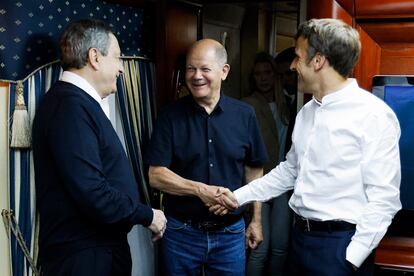 Mario Draghi (izquierda) y Emmanuel Macron (derecha) saludan al canciller alemán, Olaf Scholz, en el interior del tren que les ha llevado desde Polonia a Kiev.