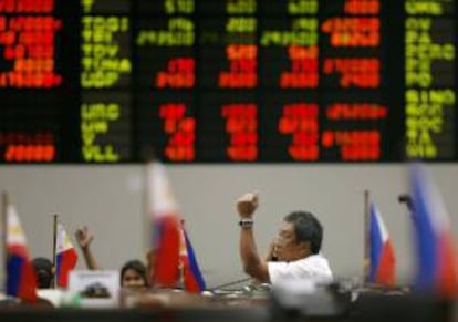 Un empleado de la Bolsa de Filipinas habla por teléfono en el parqué del distrito financiero de Makati City, Manila (Filipinas). EFE/Archivo