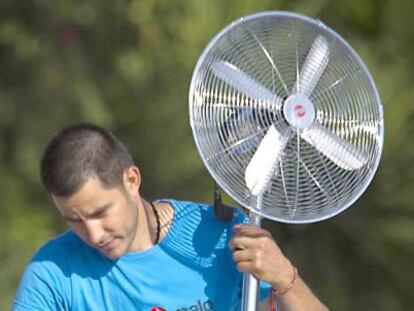 Un hombre transporta un ventilador en Sevilla.
