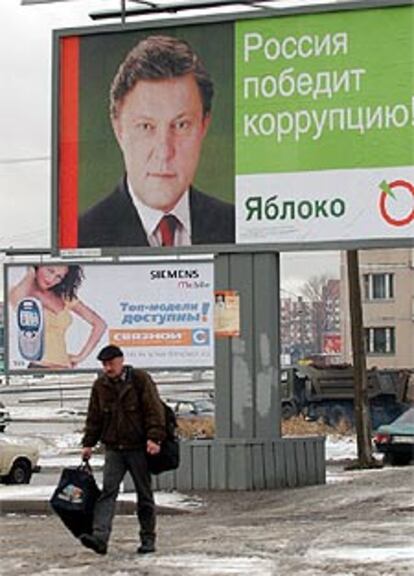 Un hombre camina junto a un cartel del partido Yábloko, ayer en San Petersburgo.