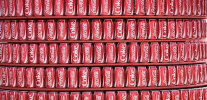 Estanter&iacute;a con latas de Coca-Cola.