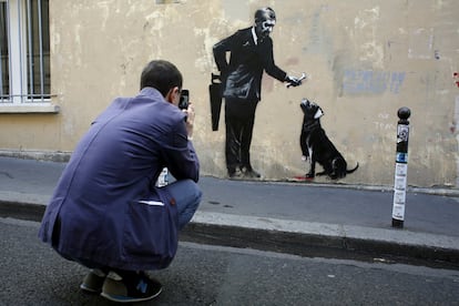 Un hombre toma una fotografía de una obra supuestamente realizada por Banksy, el 25 de junio de 2018 en París. 