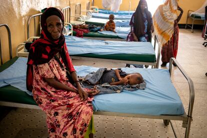 En la imagen, una madre atiende a su hijo desnutrido sentado en una sala del hospital de Dolow, Somalia, el 5 de febrero de 2022.