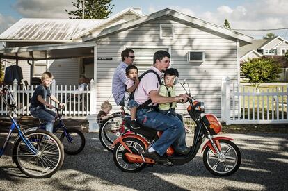 Una familia se dirige en bicicleta y ciclomotor a Pinecraft Park, donde
se ofrece comida amenizada con música.
